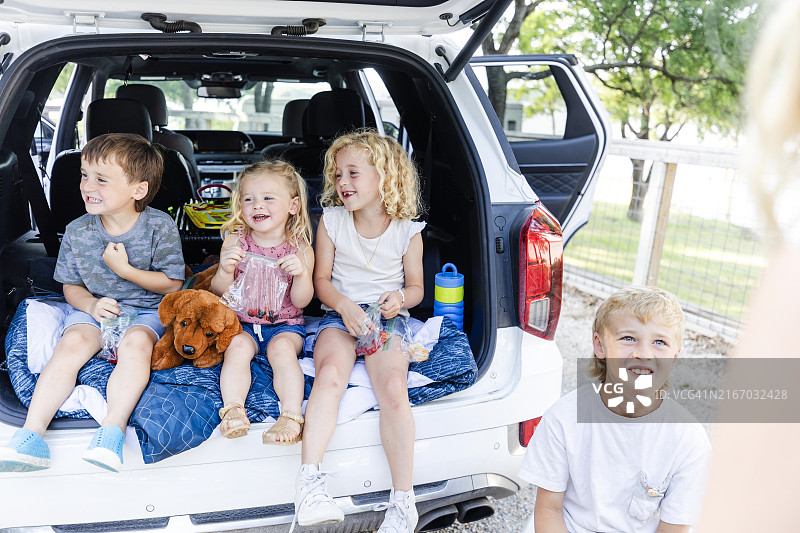 坐在汽车后座一起吃饭的儿童图片素材
