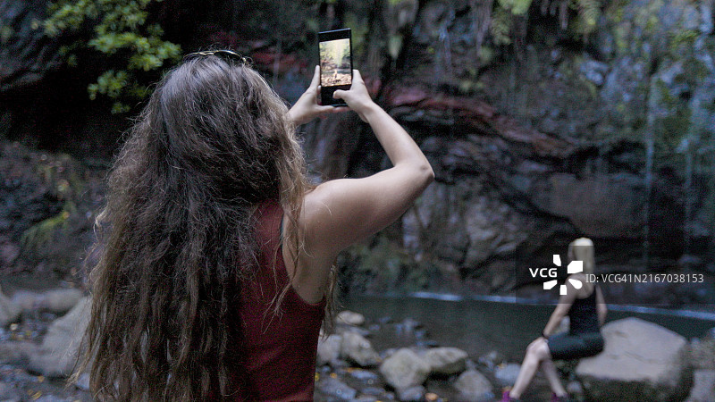 年轻女子为她的姐妹拍照图片素材