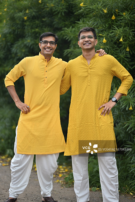 两名男子身穿黄色库尔塔，参加 हल्दी 仪式传统服饰全身像图片素材