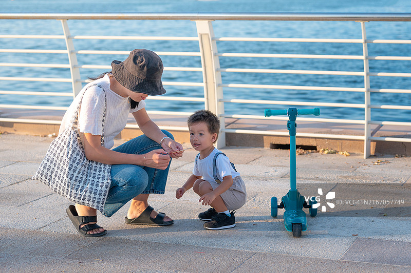 水边滑板车探险的母子二人图片素材
