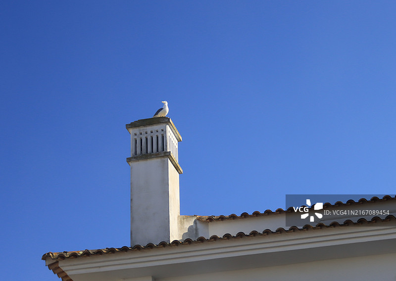 建筑物顶角上的烟囱与蓝色天空图片素材
