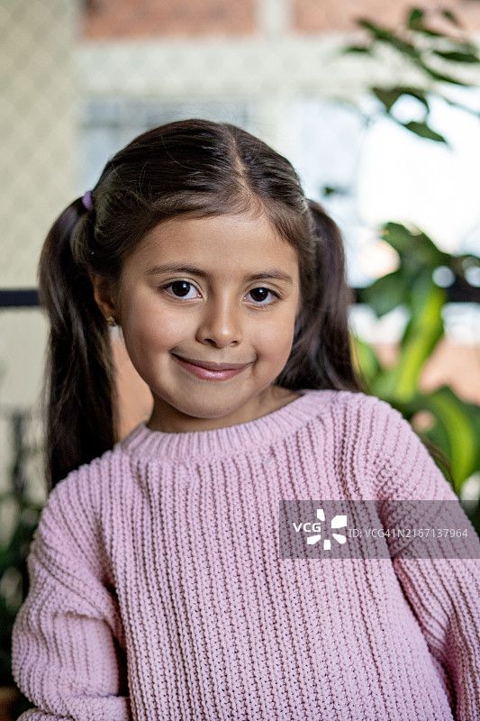 在公寓庭院里看着镜头的女孩图片素材