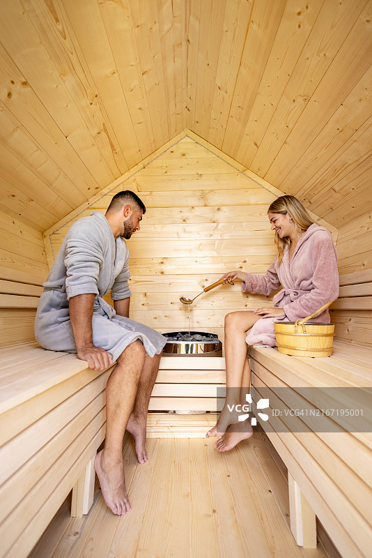 年轻夫妇坐在桑拿房里，享受放松的时光图片素材