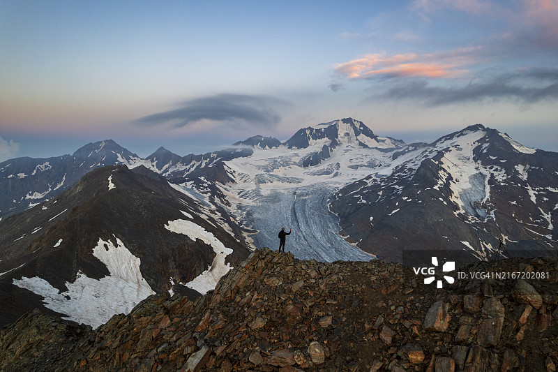 在蒂罗尔高山风光中手持智能手机的男子图片素材