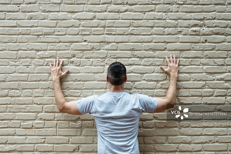 站在砖墙前的男人图片素材