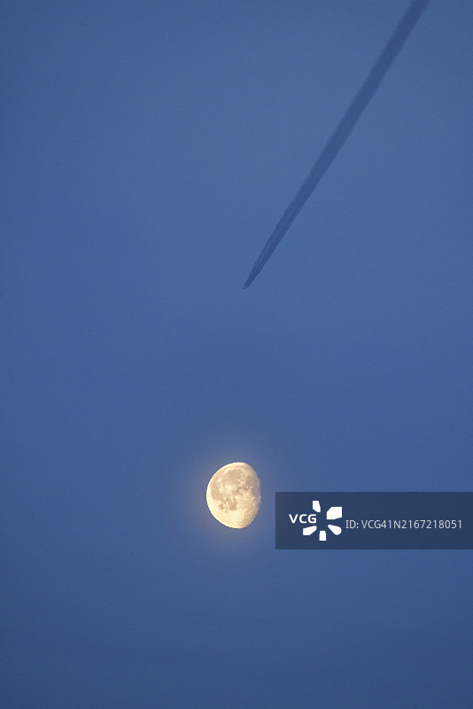 飞机尾迹剪影与月亮图片素材