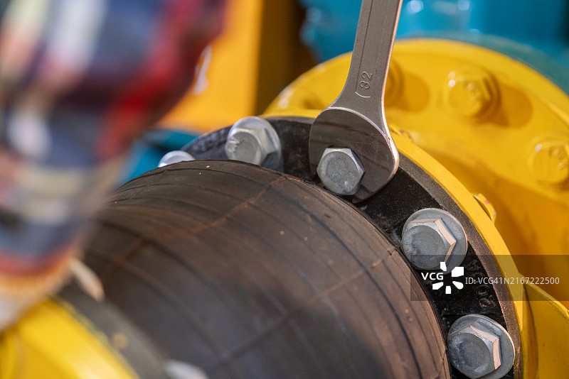 扳手拧紧工业管道螺栓的特写图片素材