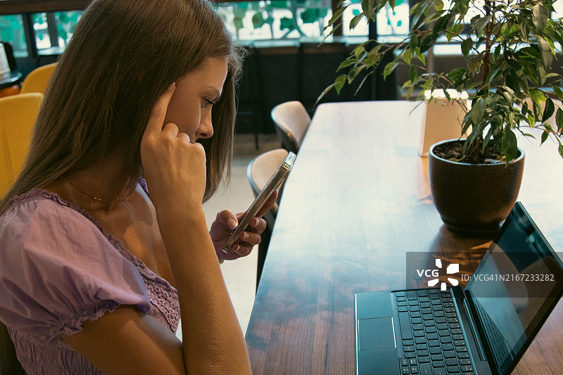 年轻女子在咖啡馆使用智能手机图片素材