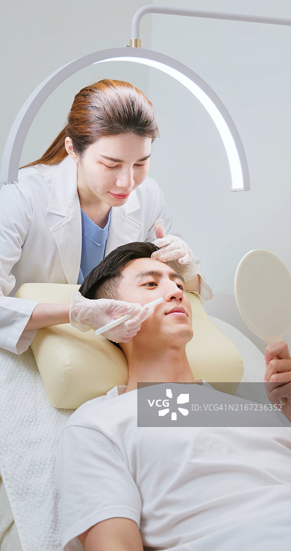 女美容师使用皮肤记号笔图片素材