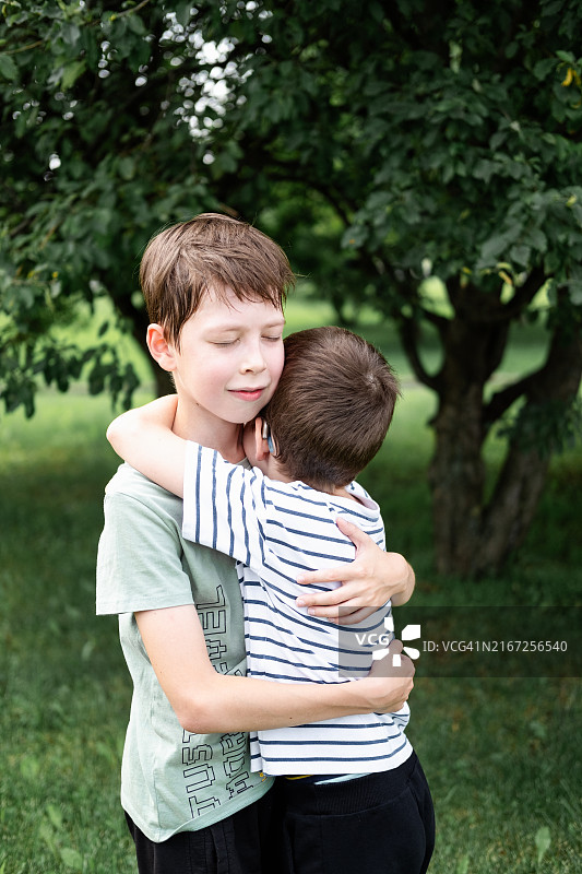 公园里，10岁和12岁的兄弟拥抱在一起，手足情深图片素材