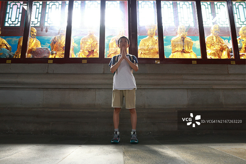 在寺庙里拜佛的男孩图片素材