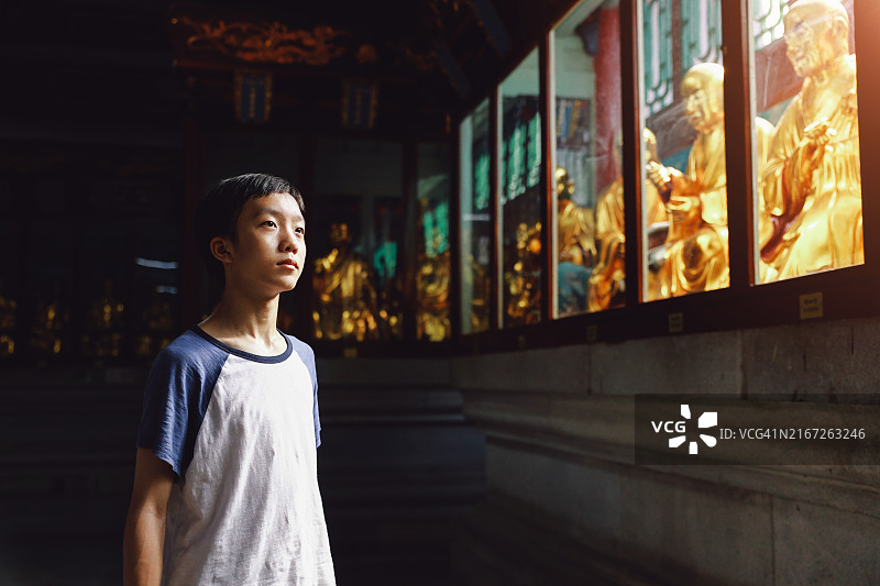 在寺庙里拜佛的男孩图片素材