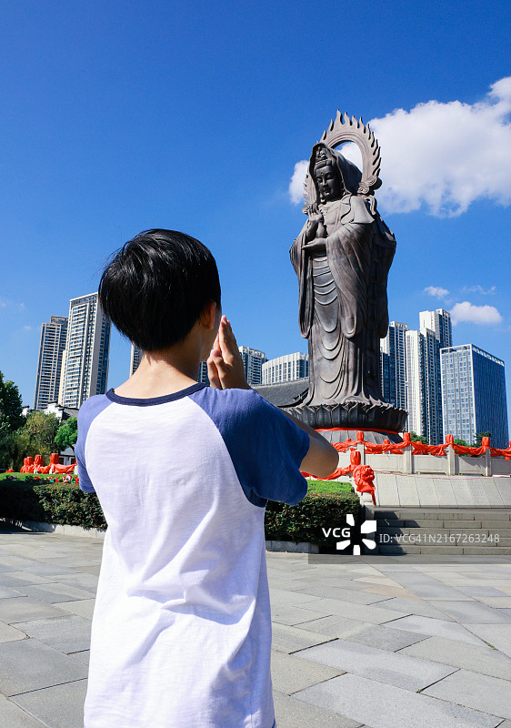 在寺庙里拜佛的男孩图片素材
