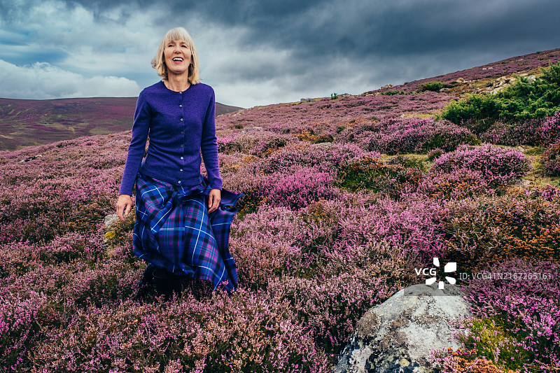身穿传统苏格兰短裙的女人，位于苏格兰高地图片素材