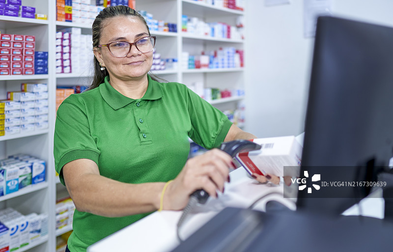 巴西女药剂师在药房用条形码扫描器扫描药品图片素材