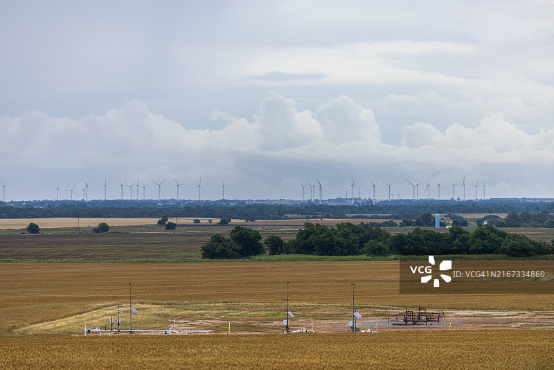 乡村景观中的可再生与不可再生资源：风力涡轮机、太阳能和油井点缀在俄克拉荷马州的金色麦田上图片素材