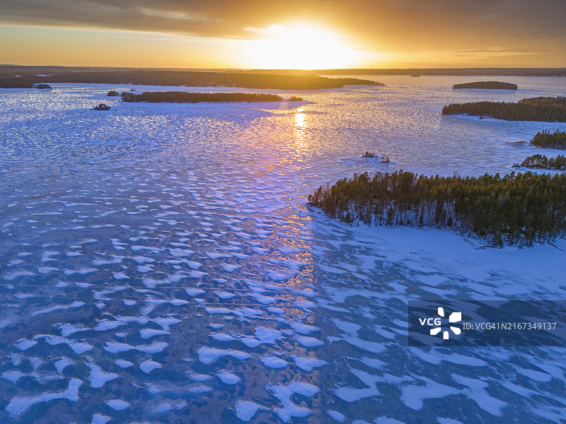 蓝色冰封湖面日落倒影，芬兰风光图片素材