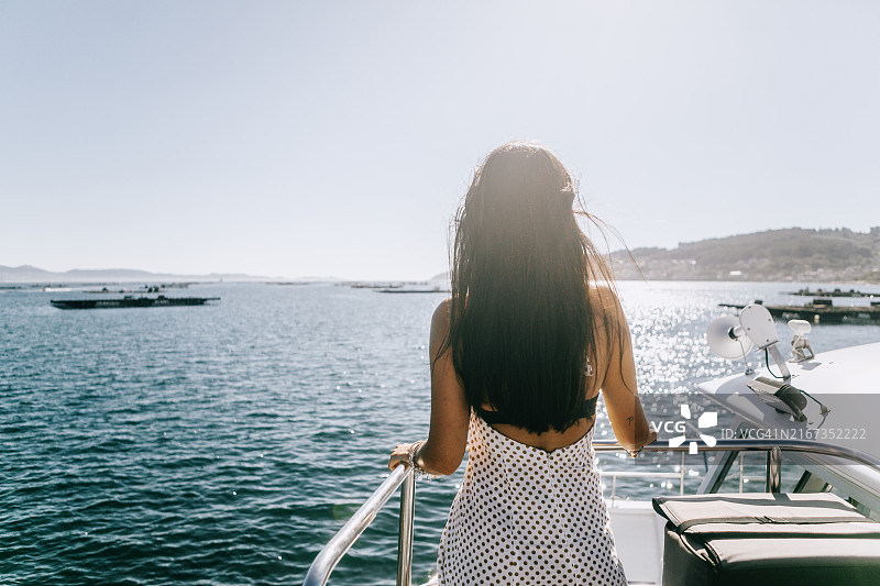 站在船上眺望大西洋的优雅西班牙裔深棕发色女子背影图片素材