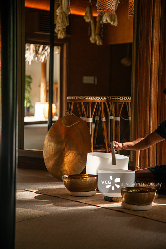 在马尔代夫豪华酒店进行声音理疗冥想的水疗师演奏水晶钵图片素材