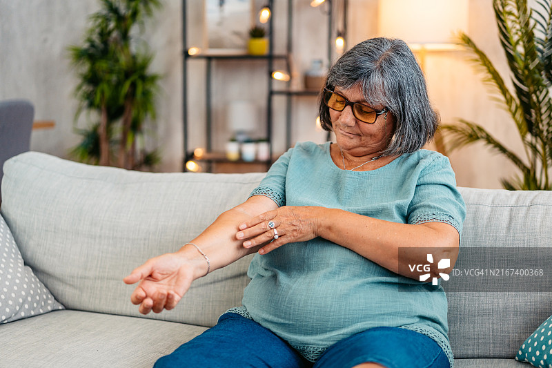 年长的女人在家挠皮肤图片素材