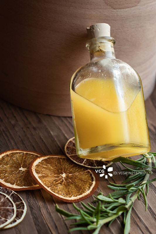 小玻璃罐里的黄色浓缩柑橘汁，旁边是一个棕色木盒图片素材