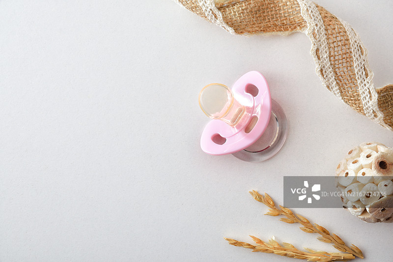 粉色奶嘴和装饰的女性婴儿背景，隔离白色图片素材