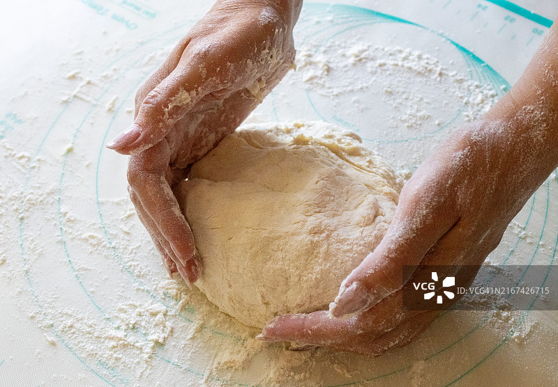 女子在桌子上揉面的局部照片图片素材
