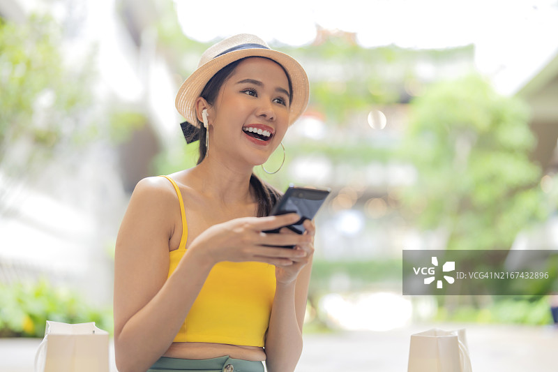快乐的亚洲时尚女性在购物中心享受夏日旅行和购物图片素材