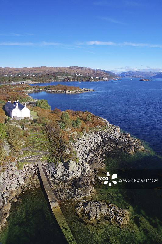 苏格兰斯凯岛洛哈尔什凯尔的岩石海岸线和白色房屋图片素材