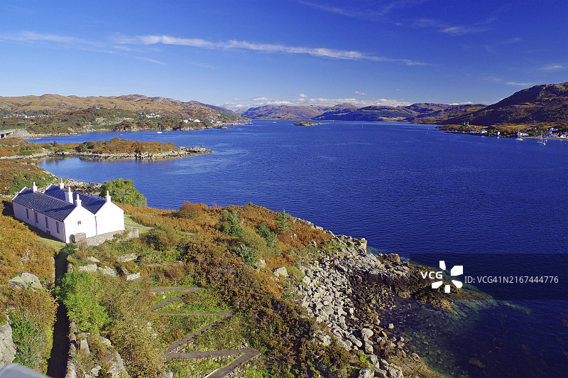 广阔的海岸景观：房屋、丘陵和大海图片素材