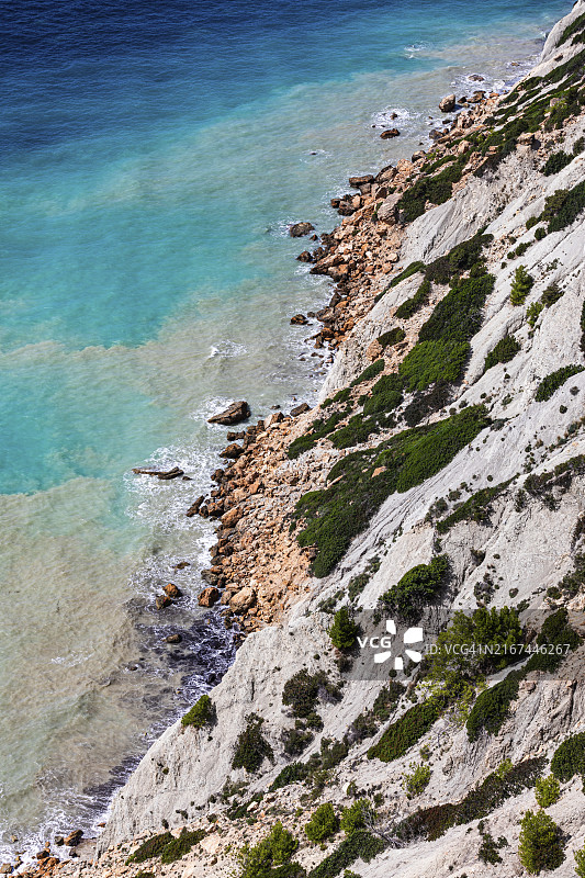 西班牙巴利阿里群岛伊维萨岛布兰克角陡峭海岸线和碧绿海水图片素材