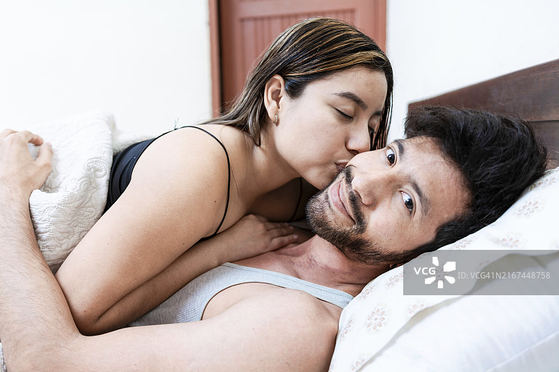 妻子在床上亲吻丈夫的额头图片素材