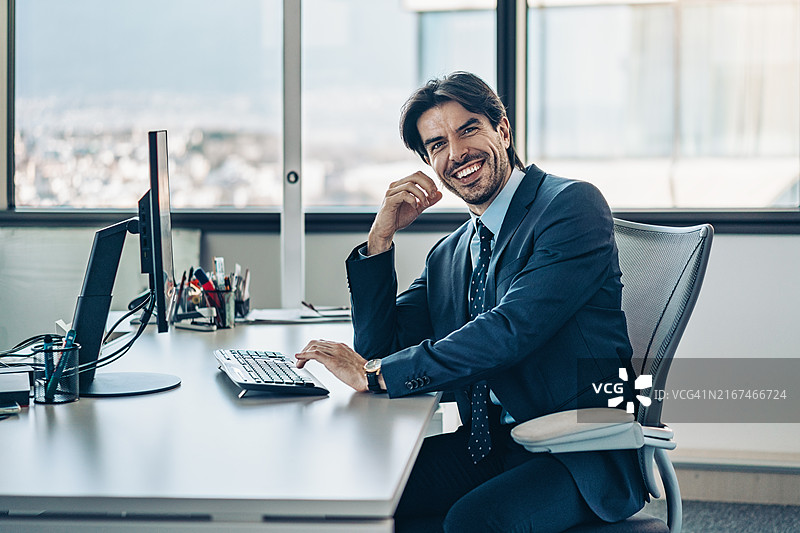 使用电脑工作的成功年轻商人肖像图片素材