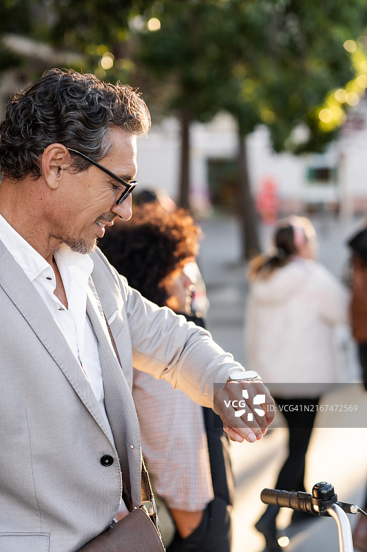 商人当街查看手表时间图片素材