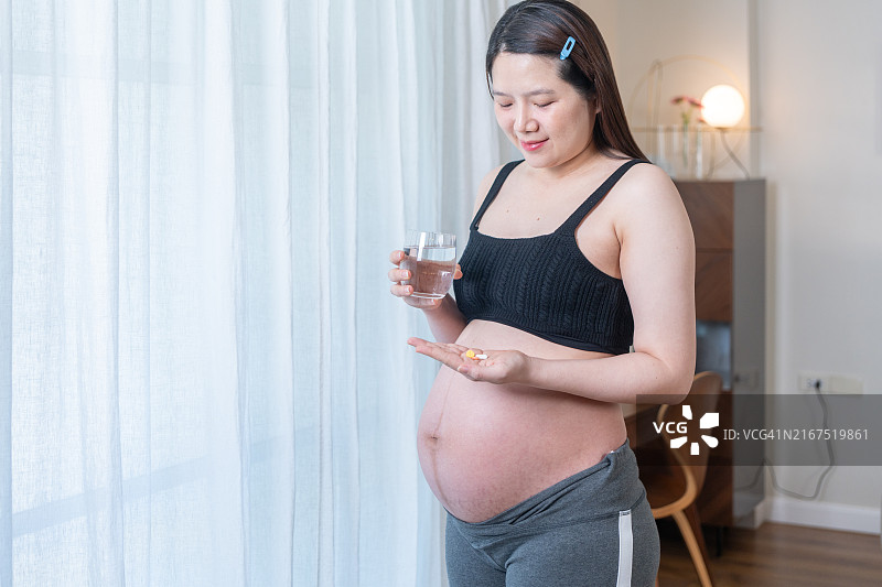 在家服用鱼油的年轻孕妇图片素材