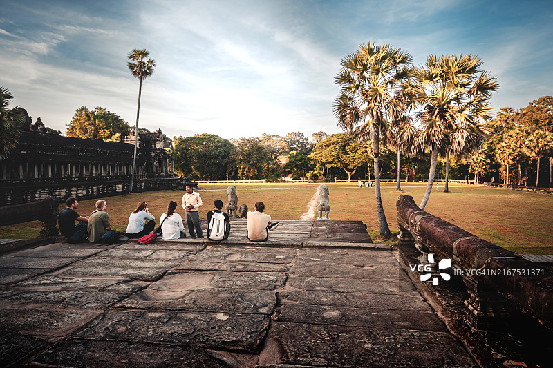 游客在柬埔寨吴哥窟听导游讲解吴哥窟历史的后视图图片素材