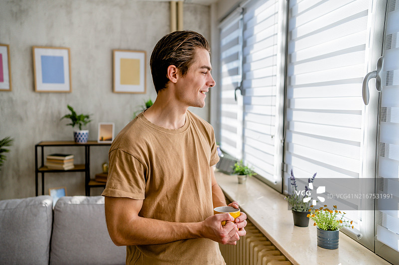 男人喝着咖啡看着窗外图片素材