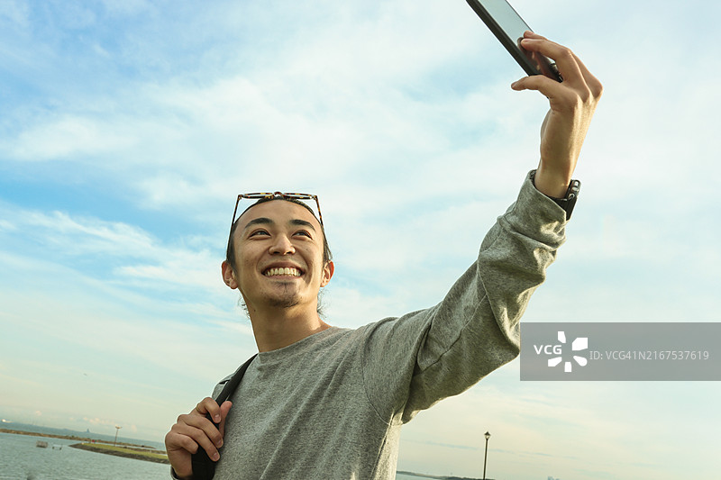 年轻男人在旅行中使用手机图片素材