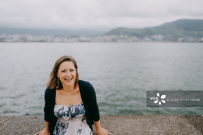 在海边对着镜头大笑的女人图片素材