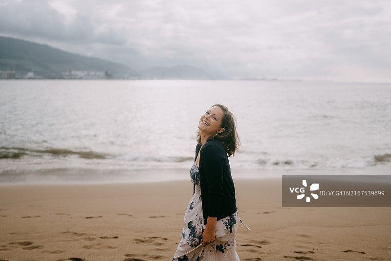 在沙滩上对着镜头大笑的女人图片素材