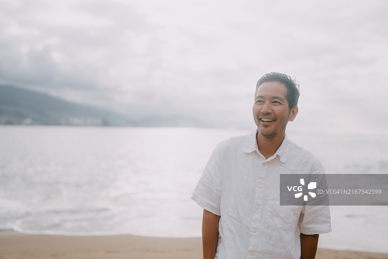 在西班牙海滩上行走的快乐男人图片素材