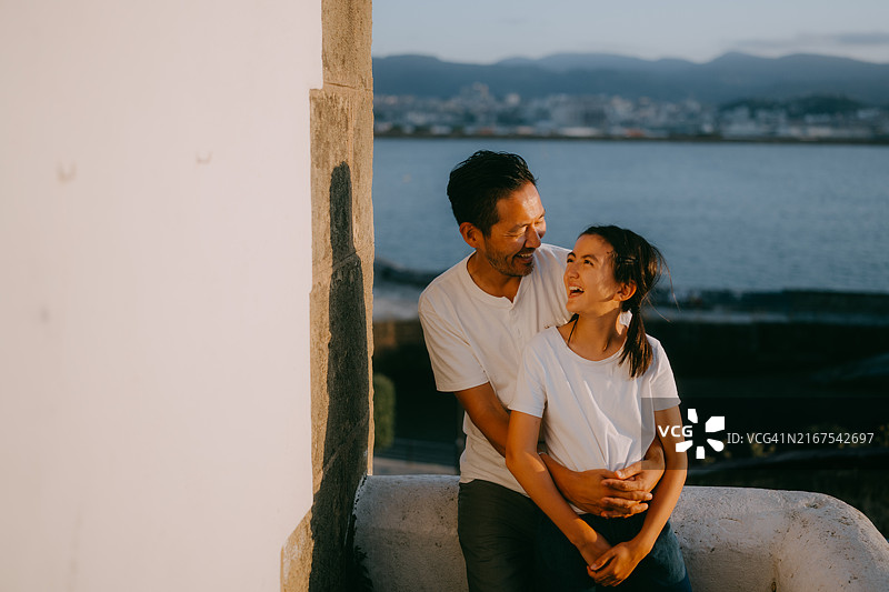日落时分，西班牙格乔，父亲和年幼的女儿在海边图片素材