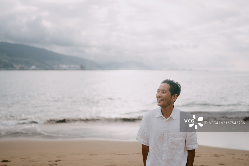 在西班牙海滩上行走的快乐男人图片素材