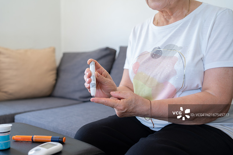 糖尿病妇女在家检查血糖水平图片素材