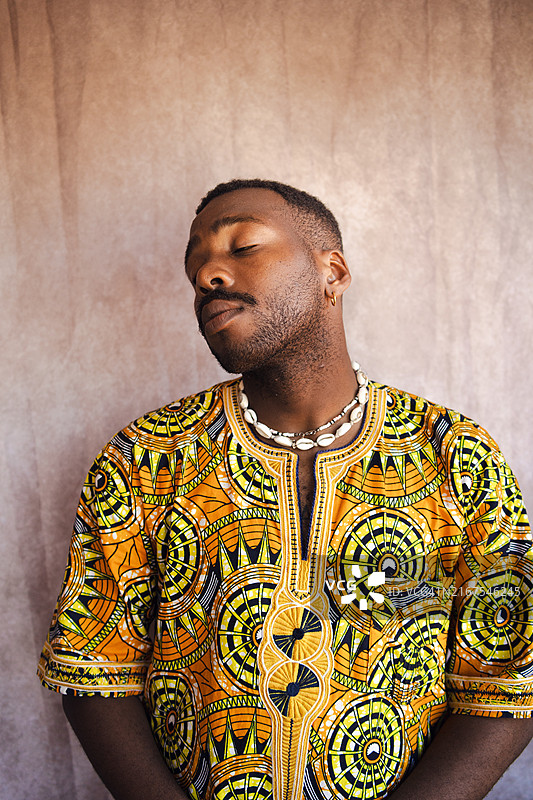 穿着传统达希基衬衫的年轻非洲男子肖像图片素材