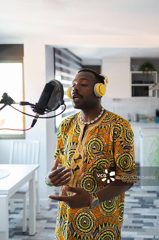 年轻音乐家在家庭工作室用高质量麦克风和耳机录制音轨图片素材