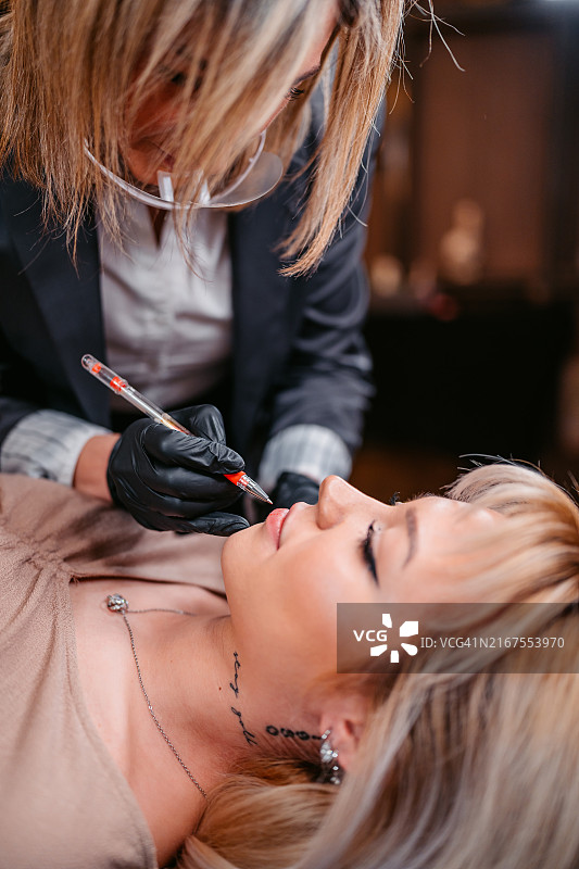 女美容师在美容院为顾客纹唇图片素材