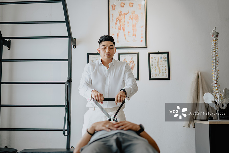 理疗师帮助男子治疗背部问题图片素材