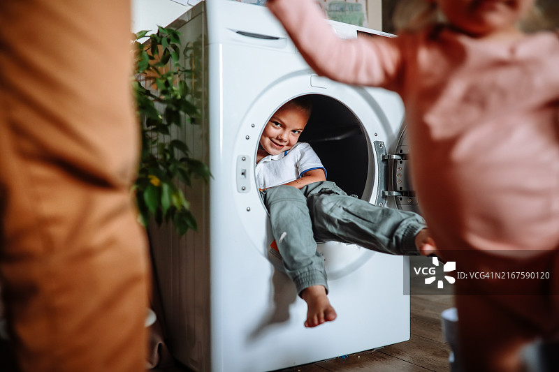 家中的欢笑与乐趣：好玩的幼儿探索洗衣机图片素材
