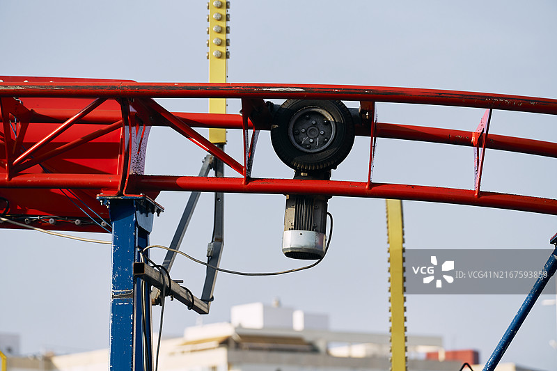 过山车轨道内电滑轮的侧视图特写，背景是天空图片素材